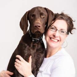 Dr. Kathy Murphy posing with what looks to be Chocolate Lab